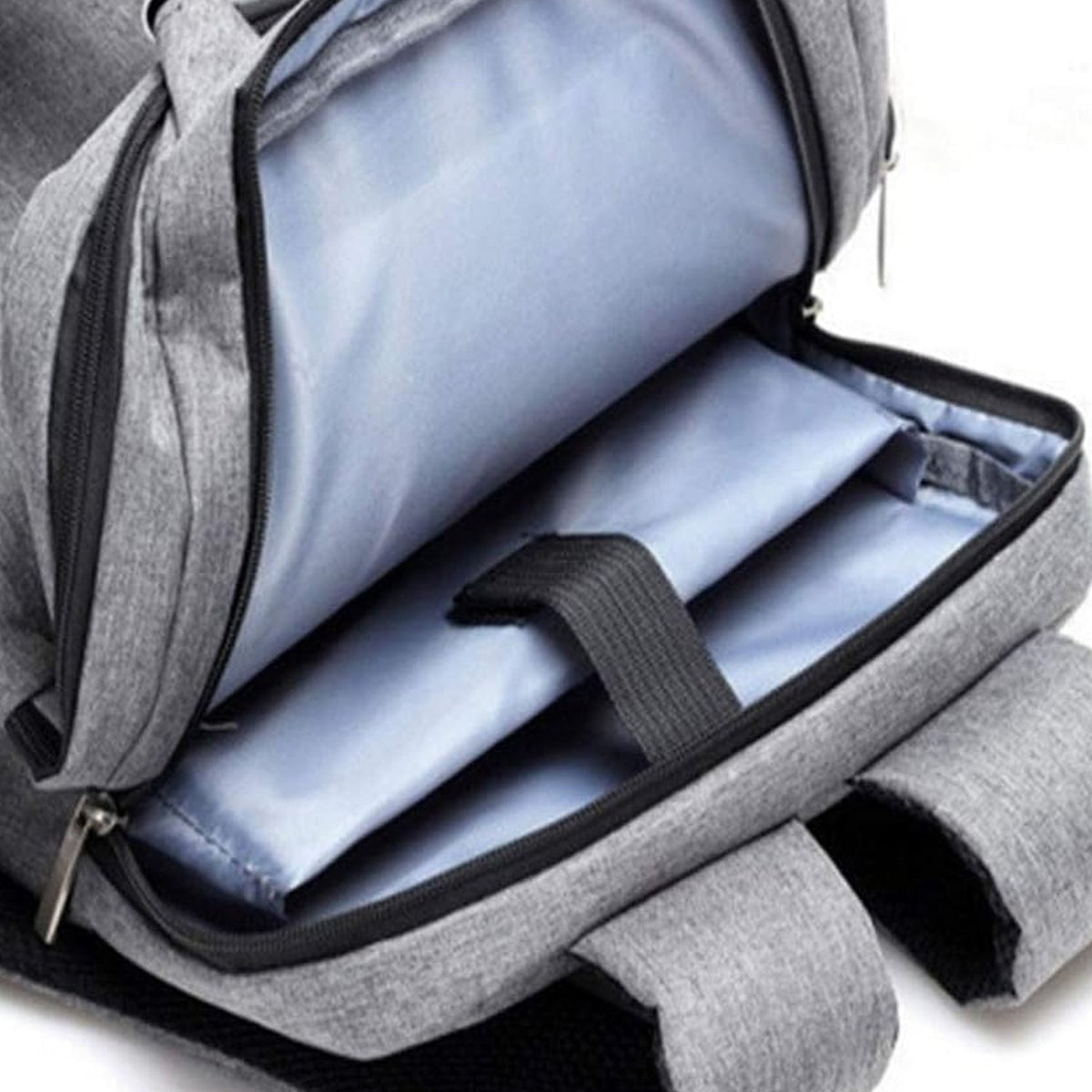 A close-up of the open main compartment of a grey backpack showing padded sleeves and light blue lining.