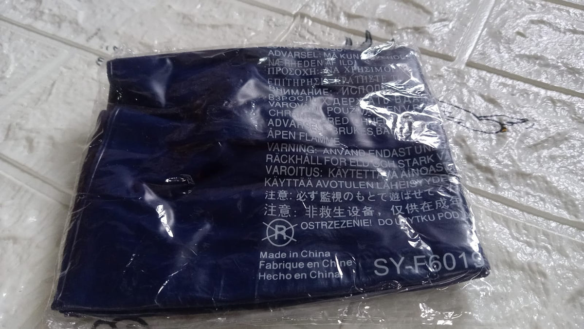 A blue inflatable pillow is sealed in clear plastic packaging, displaying product information and warnings.