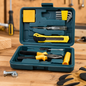 Open teal plastic toolbox on a wooden surface, displaying various yellow and black handled tools, including pliers,