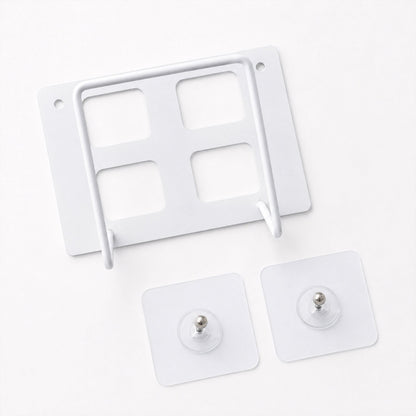 A white metal router mount with four square cutouts and two clear adhesive hooks on a white background.