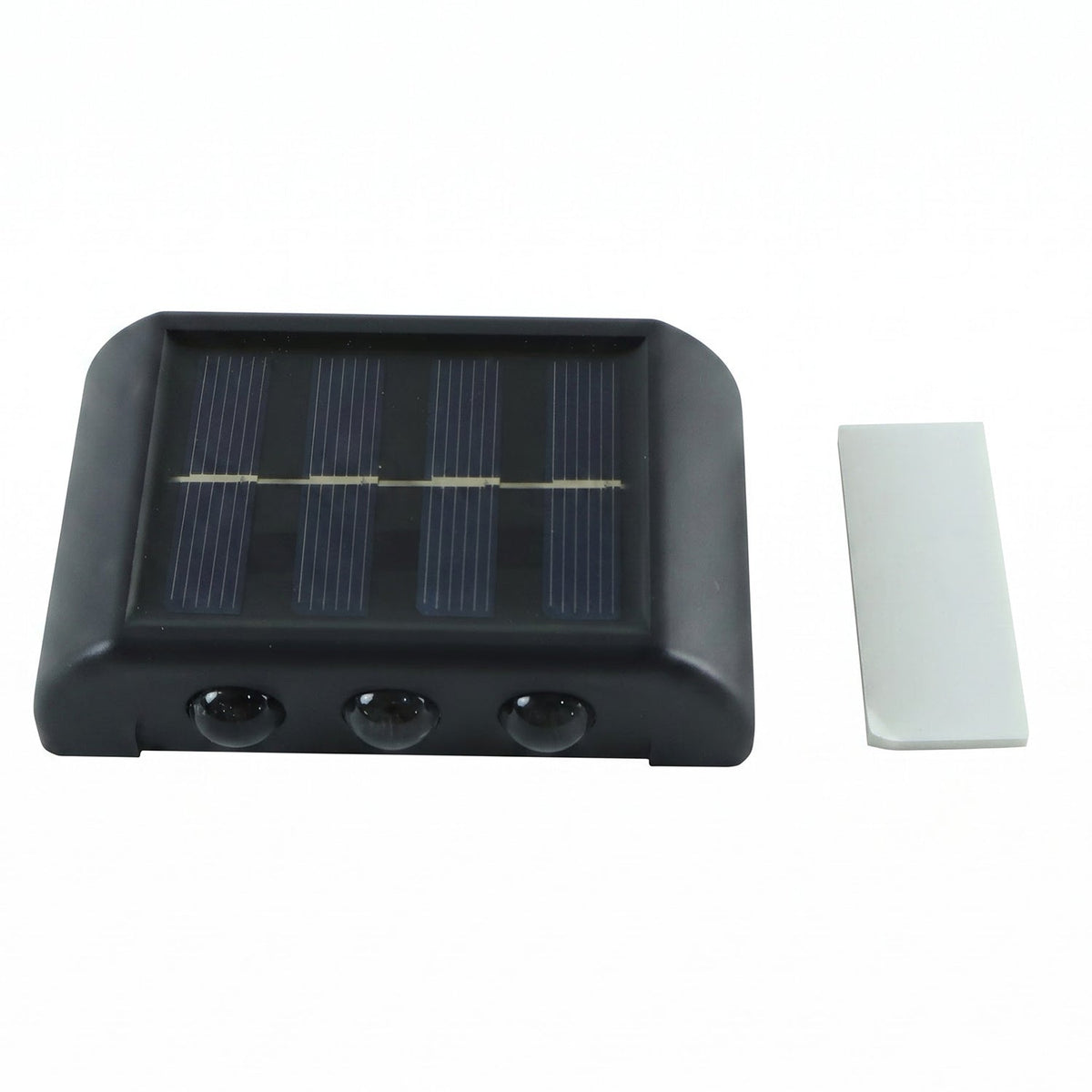 A black solar-powered LED wall light with a solar panel and three sensors, next to a white adhesive strip on a white