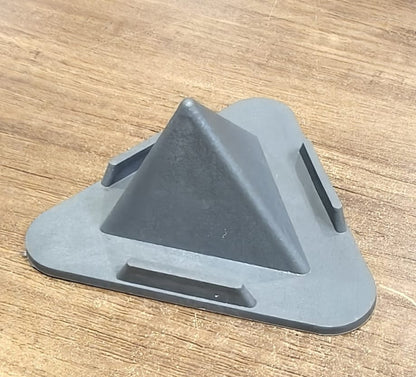 A black pyramid-shaped mobile stand with three support ledges sits on a wooden surface.
