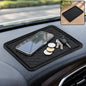 A black anti-skid mat on a car dashboard holds a smartphone, coins, and car keys. An inset shows the mat alone.