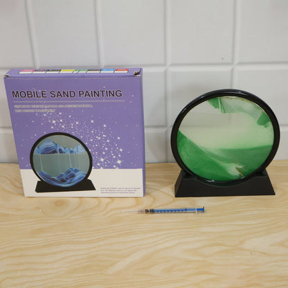 A black-framed circular sand art display with green sand next to a purple box labeled 'Mobile Sand Painting' and a syringe.