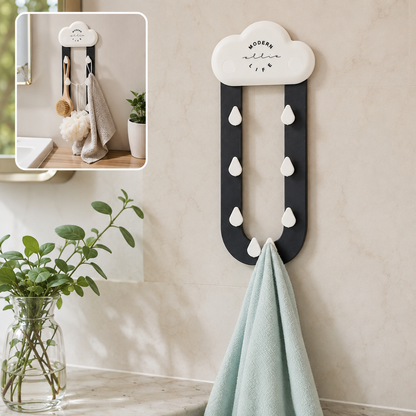 A white cloud-shaped holder with dark grey rain-like arms and white raindrop hooks, holding a light blue towel. A small