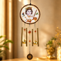 A Krishna wind chime hangs, featuring a circular medallion with a baby Krishna image and five golden metal tubes.