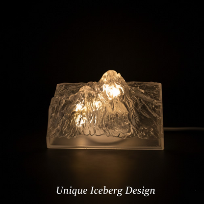 A clear, textured iceberg-shaped LED light glows warmly in a dark setting, highlighting its unique design.