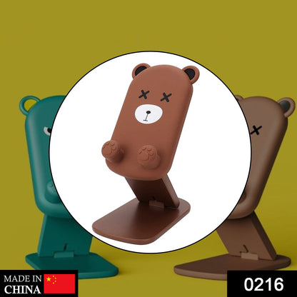 A brown cartoon bear phone stand is centered, with blurred green and brown stands in the background.