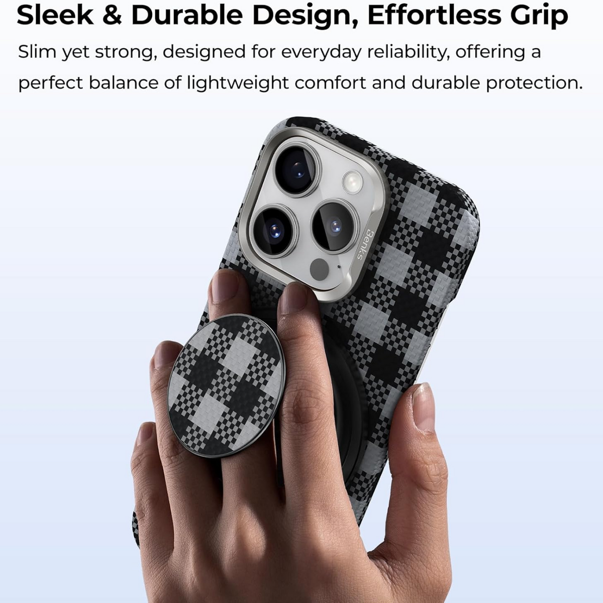 A hand holds a smartphone in a black and grey checkered case, with a matching checkered magnetic phone grip attached.