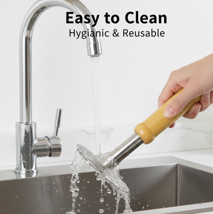 A hand holds the masher under running water from a chrome kitchen faucet, rinsing the perforated steel head in a sink.
