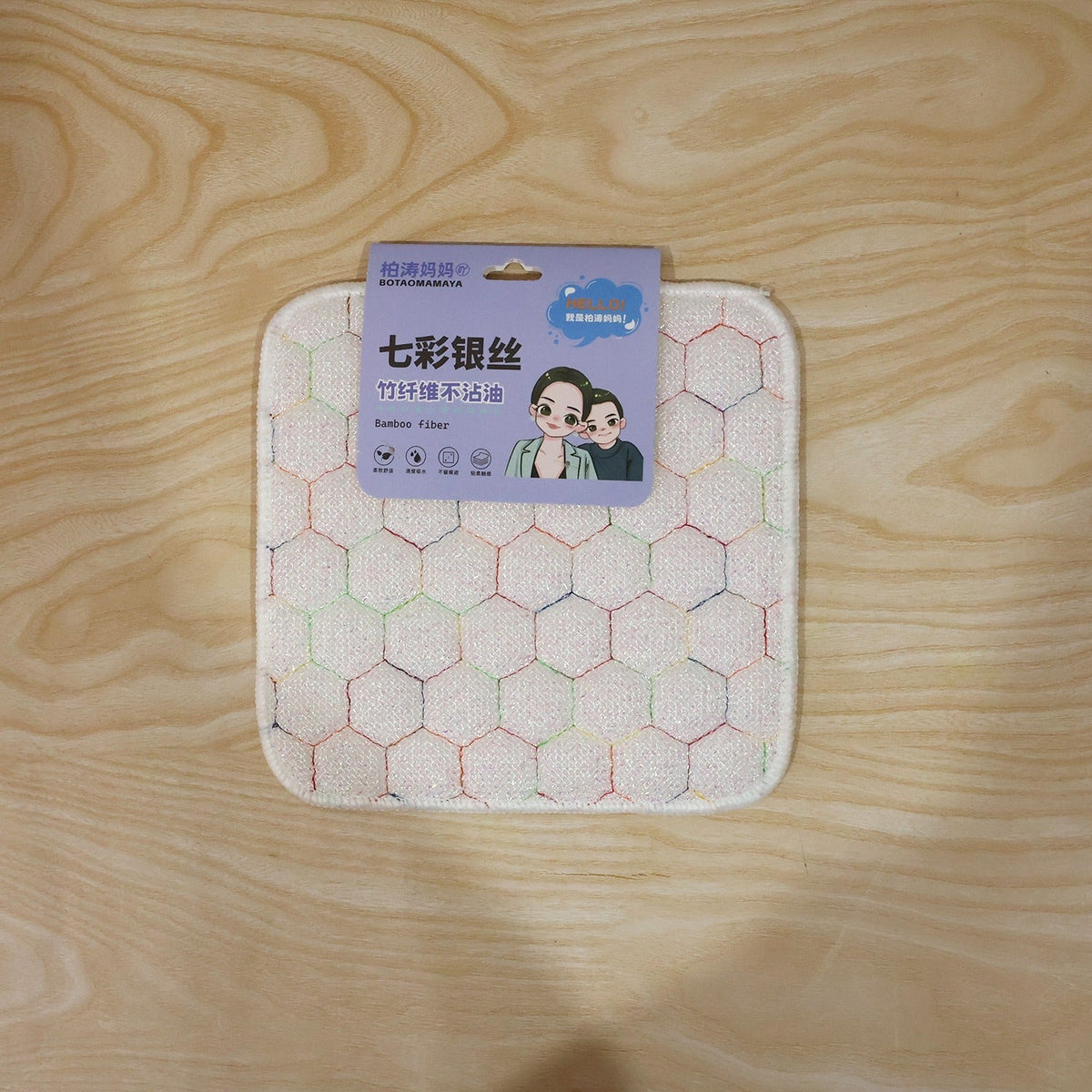 White honeycomb-patterned cleaning cloth with a purple and blue product label featuring cartoon faces and Chinese text.