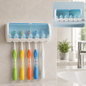 White and blue wall-mounted toothbrush holder with five colorful toothbrushes hanging in a bathroom.