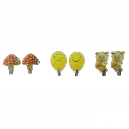 Six assorted cartoon wall hooks: two red mushrooms, two yellow smiling faces, and two sheep on skateboards, against a white