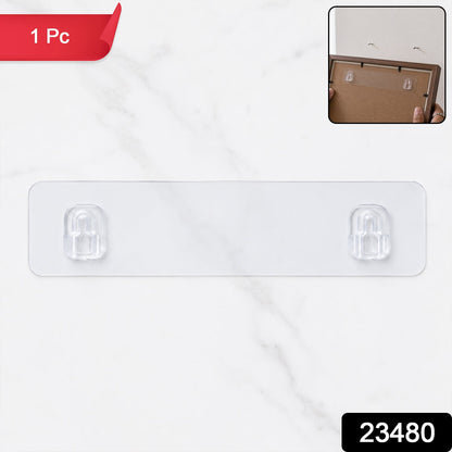 A clear adhesive wall hook strip with two hooks on a white marble background, with a small inset image showing it applied to