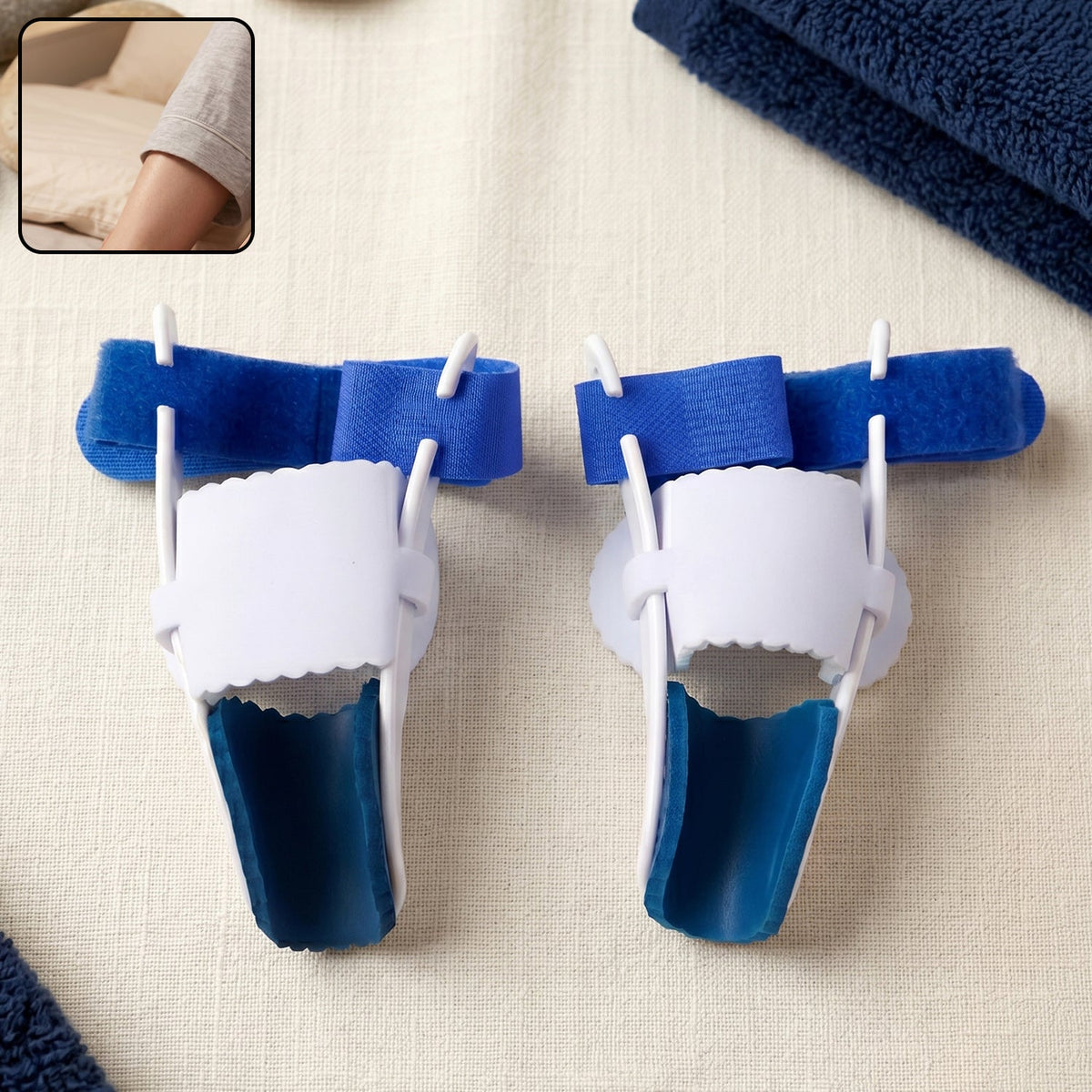 Two blue and white toe splints resting on a light-colored surface with a blue towel. Inset shows a person's arm.