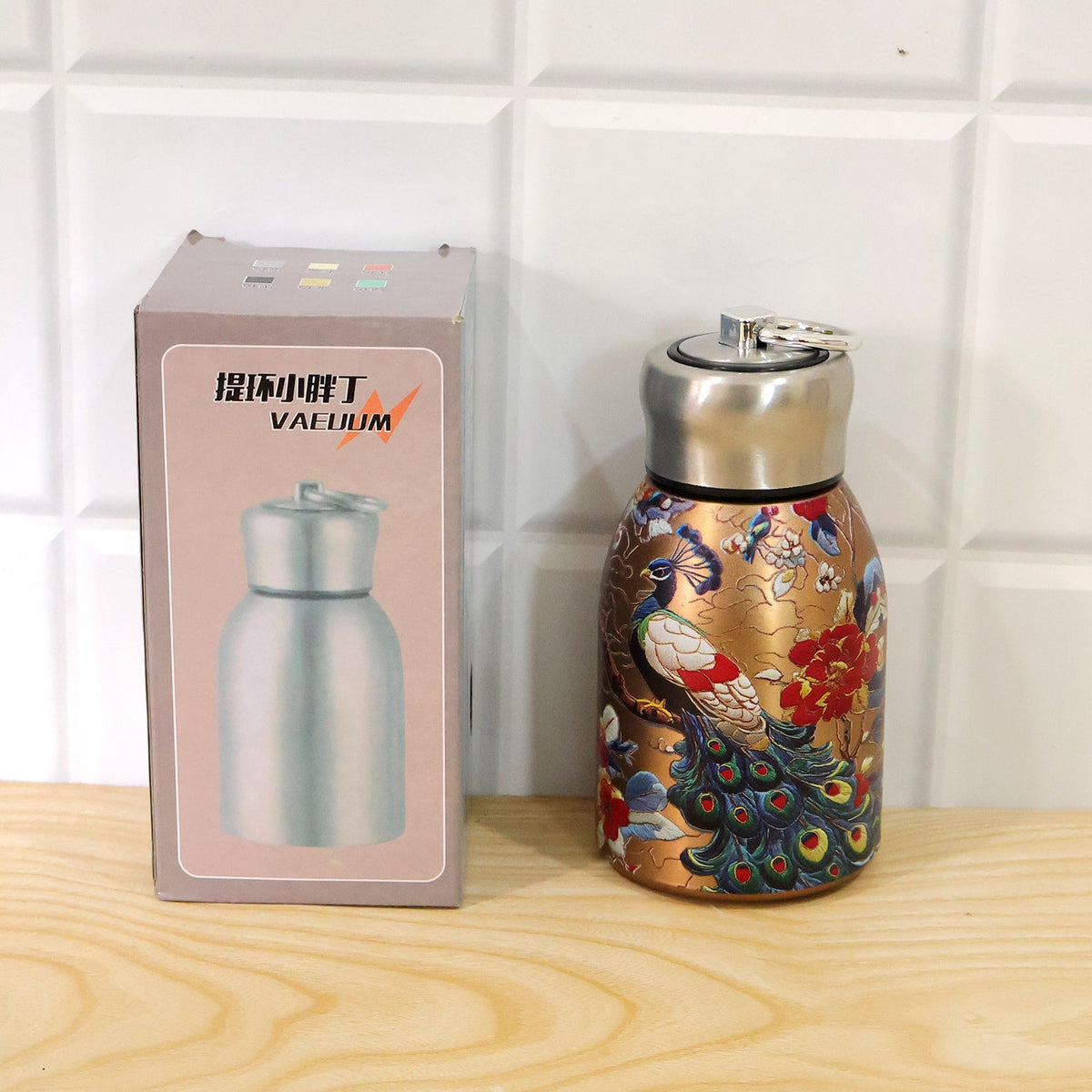 Live product photo of the Stainless Steel Vacuum Water Bottle with peacock print.