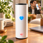 A white thermal tumbler with a blue heart and red temperature display showing 45 degrees Celsius on a wooden desk.