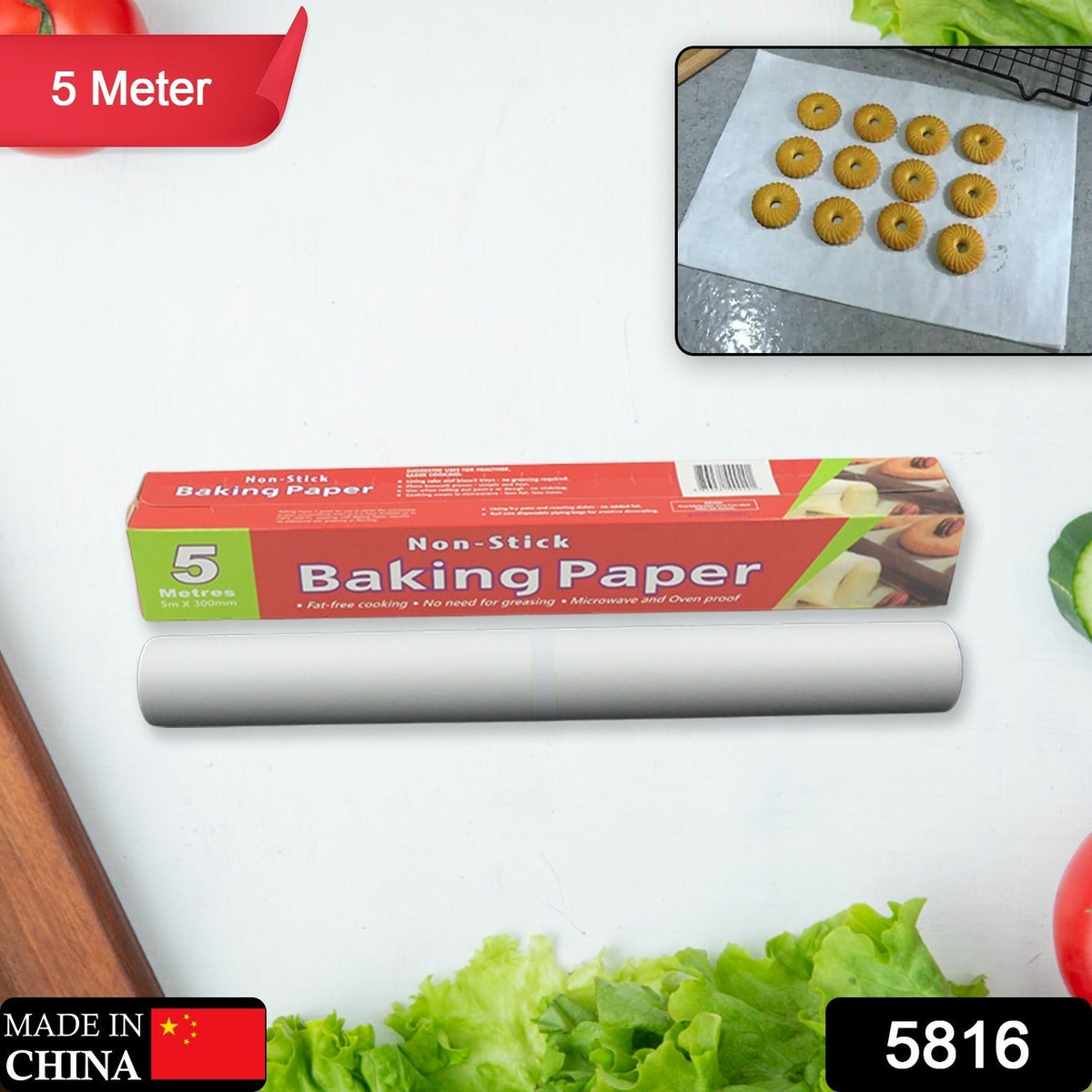 A red and green box of non-stick baking paper and a roll of the paper on a white surface with vegetables and an inset of