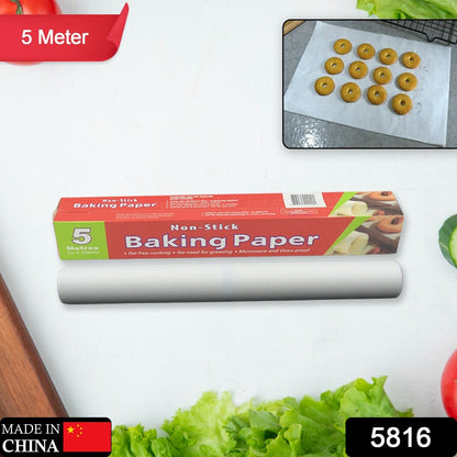 A red and green box of non-stick baking paper and a roll of the paper on a white surface with vegetables and an inset of