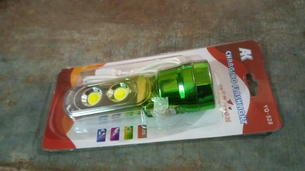 The green and silver torchlight in its clear plastic and cardboard packaging, with text "CHARGING FLASHLIGHT" visible.