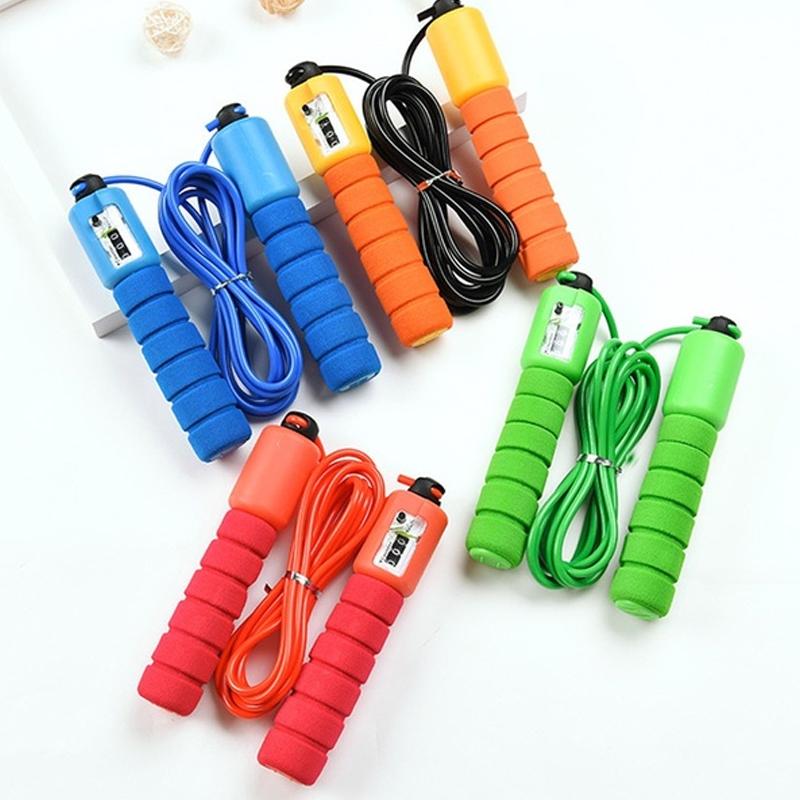 Four different colored electronic counting skipping ropes (blue, orange, green, red) with foam handles are arranged on a