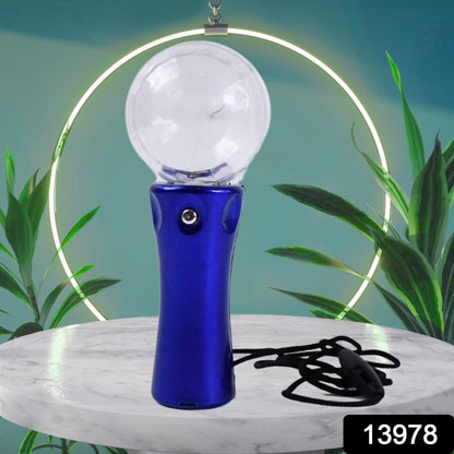 Blue disco ball light wand with a black lanyard on a marble pedestal, against a background of green leaves and a neon ring.
