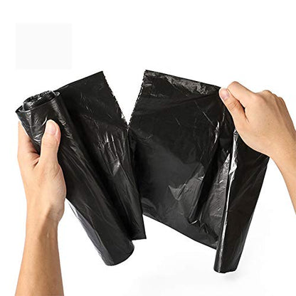 Two hands hold a black garbage bag, one hand holding the roll and the other pulling the bag open.