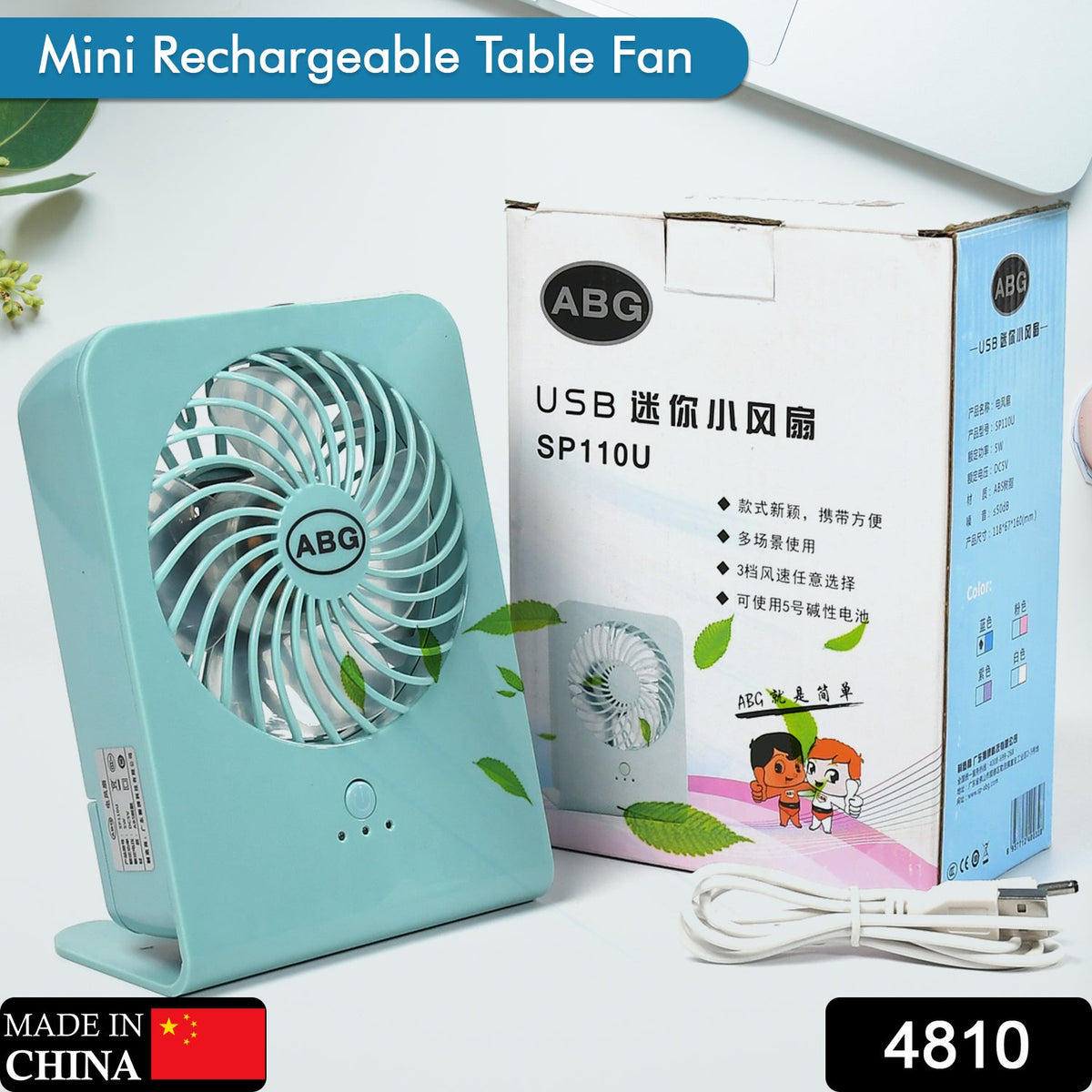 A mint green portable desk fan next to its white and brown product box, with a white USB cable.
