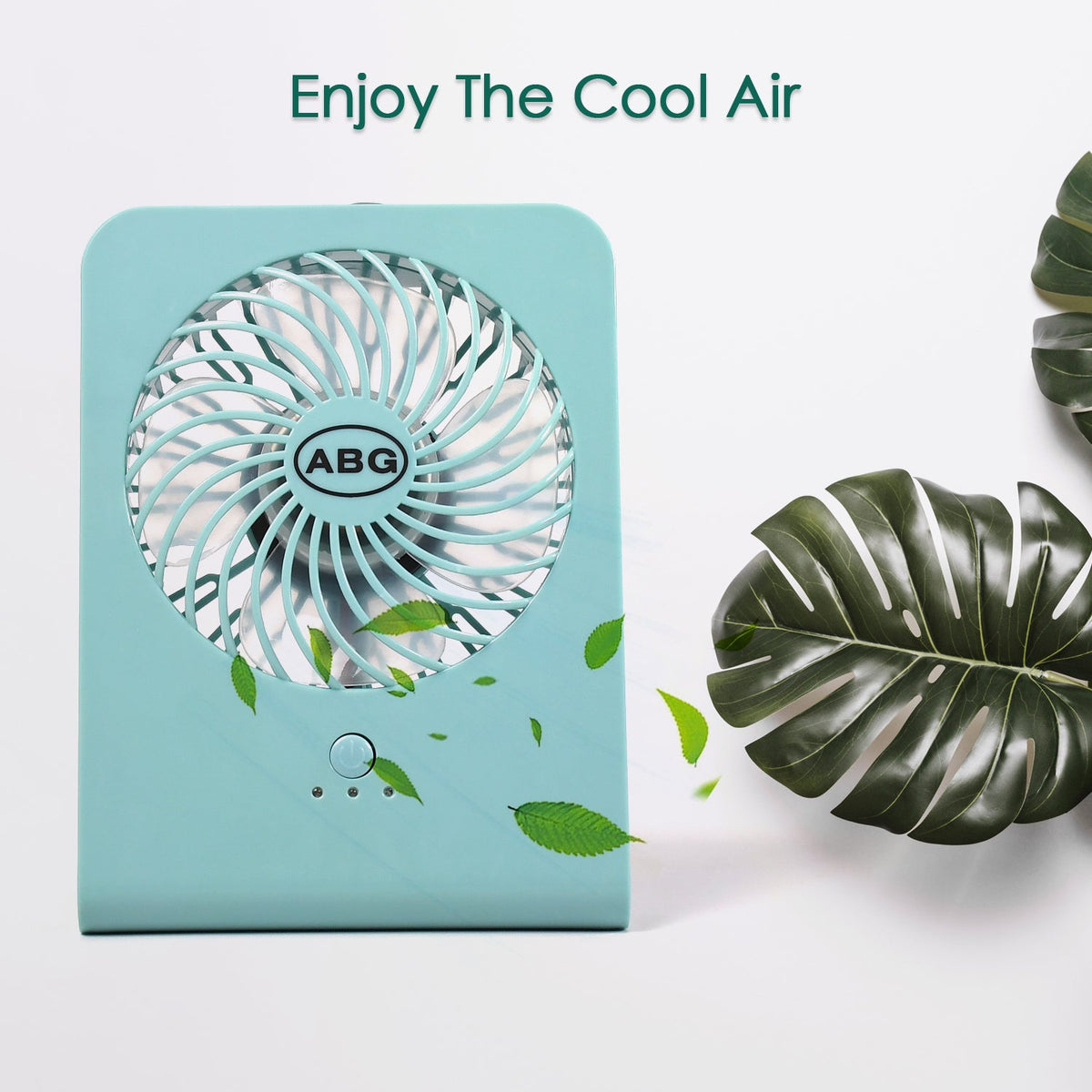 A mint green portable desk fan with green leaves seemingly blowing away from it, against a white background.