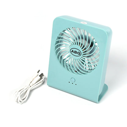 A mint green portable desk fan and a coiled white USB cable on a plain white surface.