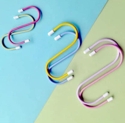 Six colorful plastic coated S hooks in yellow, blue, pink, and purple, arranged on a blue and green background.