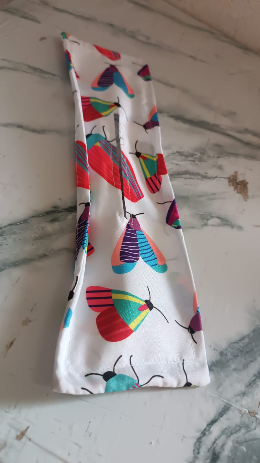 Floral print hair bun maker with an abstract design, displayed neatly on a wooden surface.