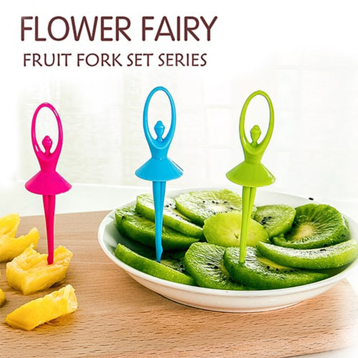 Three colorful dancing doll fruit forks, pink, blue, and green, on a wooden board with sliced kiwi and pineapple.