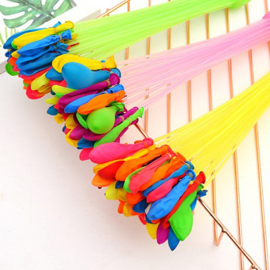 Three bunches of colorful water balloons with green, pink, and yellow nozzles, angled on a white surface.