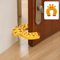 A yellow giraffe-shaped EVA door stopper is wedged on a brown door, preventing it from closing.