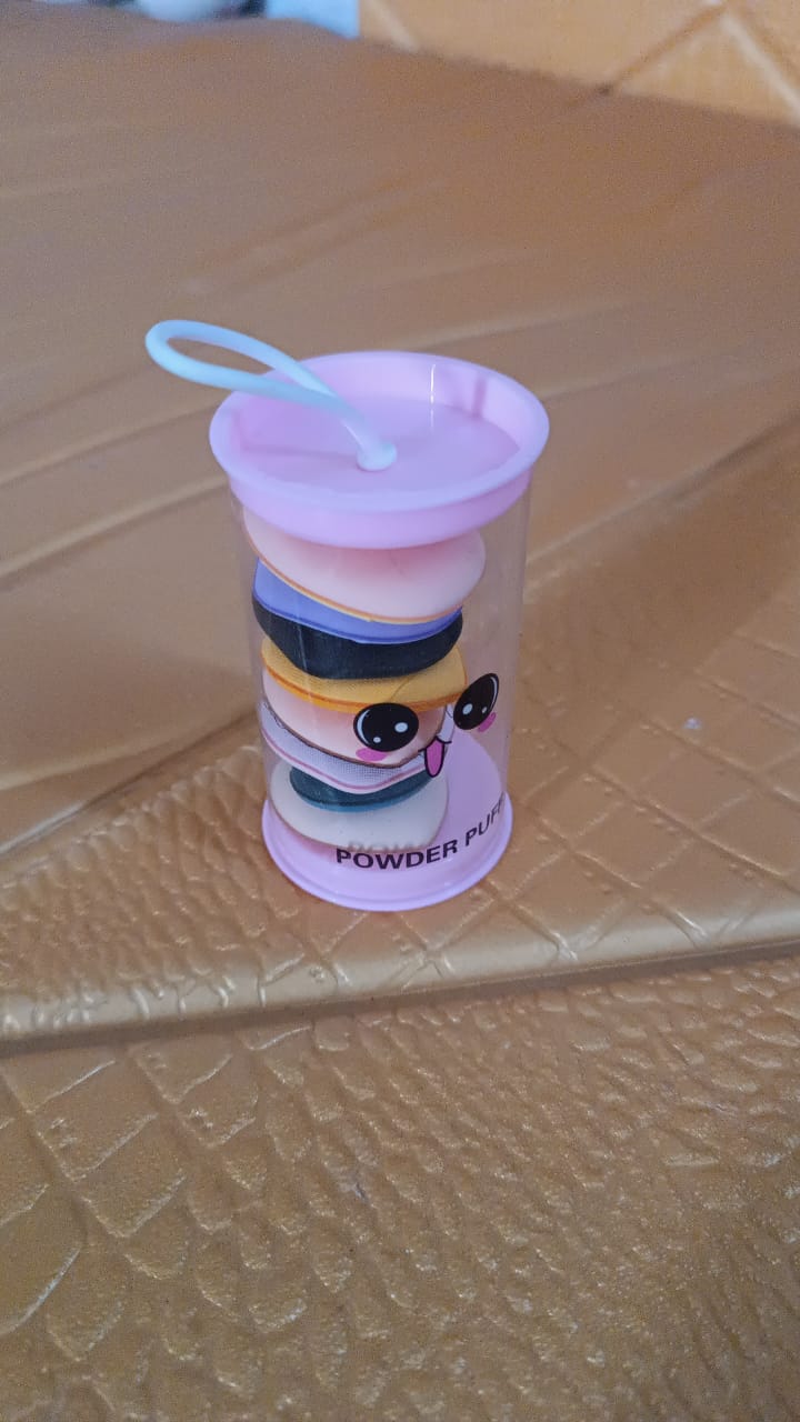 A clear pink-capped tube containing eight stacked mini makeup sponges with a cartoon face on the side.