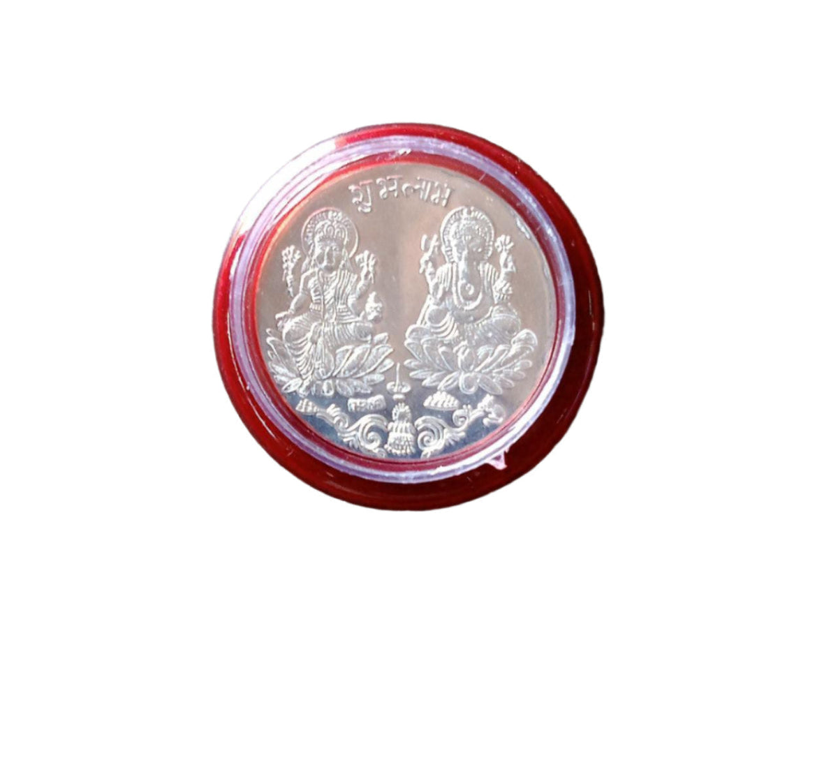 A silver coin with Lakshmi and Ganesha in a red and clear plastic case, isolated on a white background.