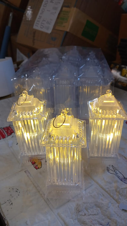 Three glowing LED crystal lantern lamps are displayed with their clear packaging in a casual indoor setting.
