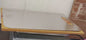A stainless steel cutting board with ruler markings and 'Chef' engraving, resting on a brown surface.