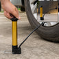 A hand operates a gold and black hand pump to inflate a car tire, with an inset showing the pump alone