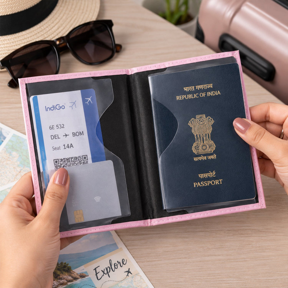 Hands hold the open pink passport holder, displaying a dark blue passport and a boarding pass within its clear pockets.