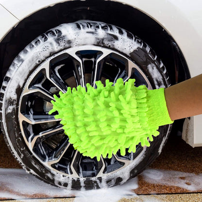 A hand wearing a bright green microfiber glove cleans a car wheel with black spokes and white suds.