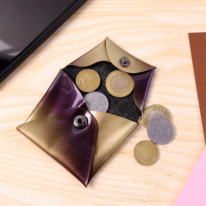 An open iridescent coin pouch with purple and gold hues holds several Indian coins on a wooden surface.