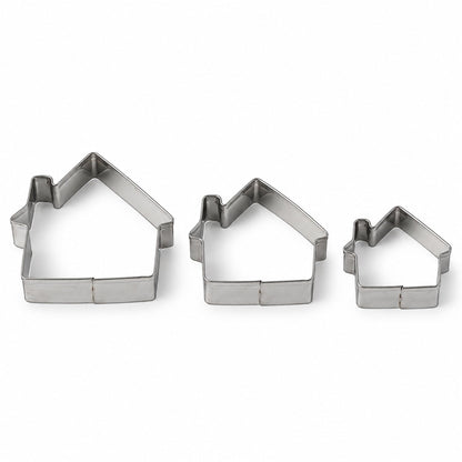 Three silver house-shaped cookie cutters of varying sizes arranged on a plain white background.