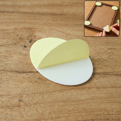 A white oval pad with its yellow adhesive layer partially peeled, on a wooden surface with a small inset showing its use.