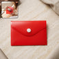 A red plastic document folder envelope with a white button closure lies on a light marble surface, with an inset showing a