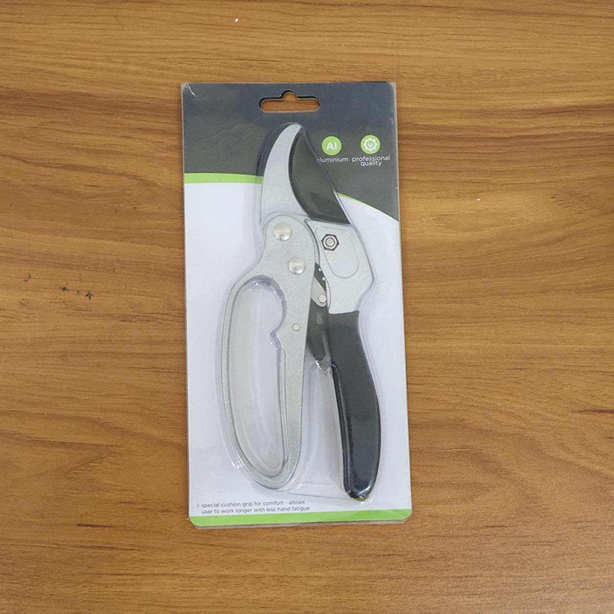 Indo Glow silver and black ergonomic pruning shears displayed next to fresh green foliage, ready for garden tasks.
