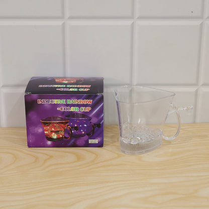 A clear heart-shaped mug sits next to its purple box, which features images of the glowing cups.
