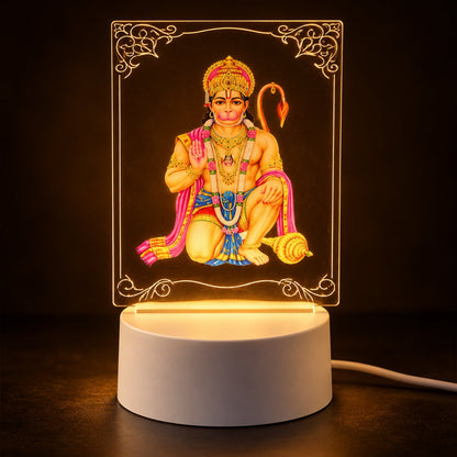 A Hanuman LED acrylic night lamp glowing warmly in a dark room, highlighting the intricate design and light base.