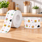 A roll of white sealing tape with colorful cartoon characters sits next to two smaller stacked rolls on a wooden counter.